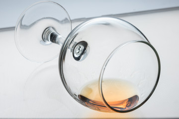 overturned glass goblet with alcohol inside