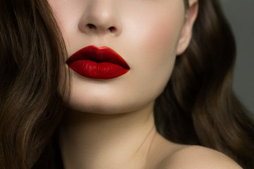 Close-up of woman's lips with fashion natural red lipstick makeup. Macro sexy pale lipgloss make-up...