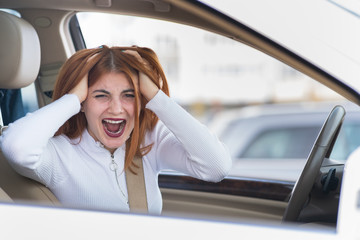 Closeup portrait of pissed off displeased angry aggressive woman driving a car shouting at someone. Negative human expression consept.