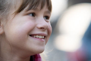 Portrait of happy child girl in warm clothes in autumn outdoors.