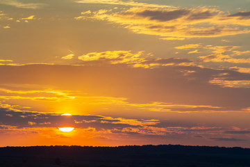 Sunset sky covered with orange puffy clouds in the evening.