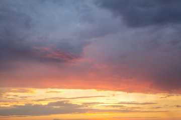Sunset sky covered with orange puffy clouds in the evening.