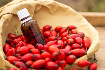 Rose-hips and rose hip seed oil on the wooden table. Rose hip  commonly known as rose hip (Rosa canina). 