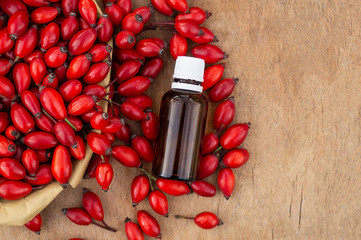 Rose-hips and rose hip seed oil on the wooden table. Rose hip  commonly known as rose hip (Rosa...