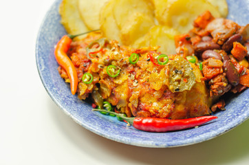 Chicken breast fillet with a chilli and cheese tomato sauce with crispy potato slices and minty bean salad on a blue plate