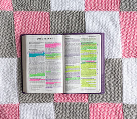 Open Bible flat lay on white, grey and pink background 