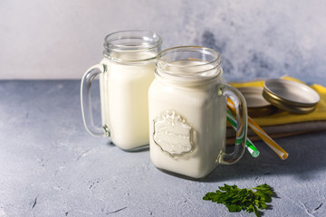 simple homemade kefir in a glass with spices and herbs on a gray background, copy space. Probiotic Ayran