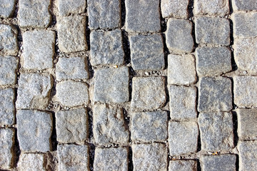 An old stoneblock pavement cobbled with square granite blocks