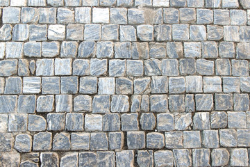 An old stoneblock pavement cobbled with square granite blocks