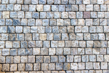 An old stoneblock pavement cobbled with square granite blocks
