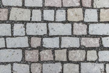 An old stoneblock pavement cobbled with square stone blocks