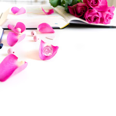 Pink Bible flat lay with: pink rose petals, open Bible, journal, pen