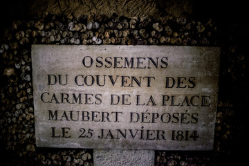 Skulls and bones in Paris catacombs, France. Old broken skull placed on the bones. Underground...