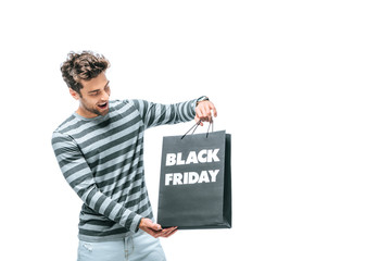 excited man holding shopping bag on black friday, isolated on white