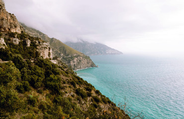 Beautiful landscape view with turquoise sea and rocky slopes covered with evergreens of the Amalfi coast