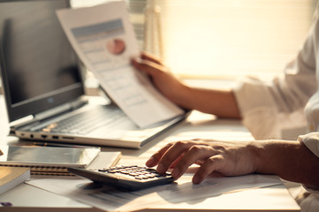 Hand of Business people calculating interest, taxes and profits to invest in real estate and home buying