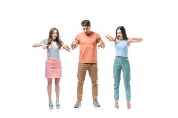 Naklejka premium shocked friends standing together and pointing down, isolated on white