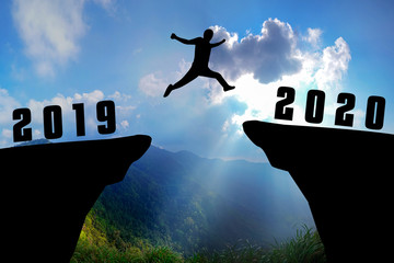 Silhouette young man jumping from 2019 to 2020 years