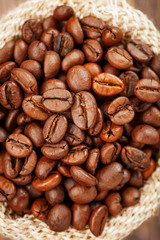 Coffee beans closeup in burlap bag on wooden background.