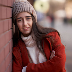 Lifestyle portrait of a beautiful brunette girl in hat. Outdoor shot of people emotions.