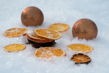 Merry Christmas and  New Year greeting card with dry orange, Clementines tangerines anf gold ball on snow