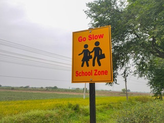warning sign on road near school