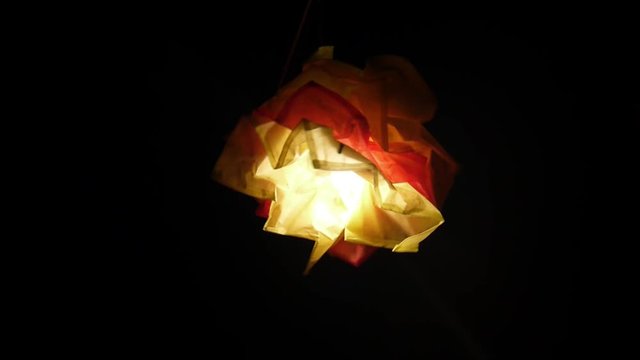 light bulb in a homemade lampshade in the dark