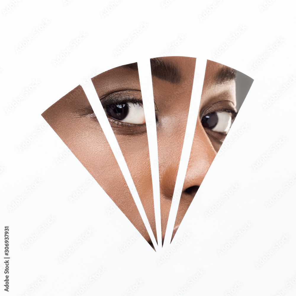 Wall mural afro woman with natural makeup looking through geometry hole in paper