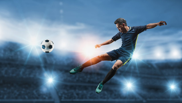 The concept of playing football.Soccer player kicks the ball on the soccer field.Professional soccer player in action.