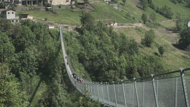 Tartano, Italy. June, 07,2019: Wide angle of suspended tibetan bridge.