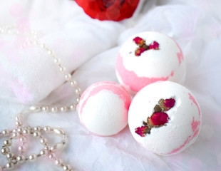 Fototapeta na wymiar Bath balls, towel, pearl and red rose on white background. Romantic spa wellness concept. Valentines day, Mothers day or wedding celebration spa closeup composition.
