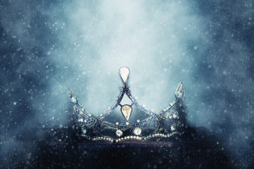 mysterious and magical photo of of beautiful queen/king crown over gothic snowy black background....