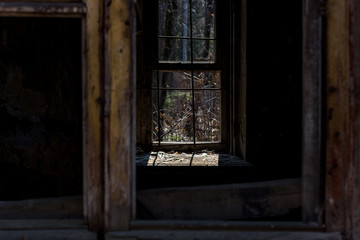 Fototapeta na wymiar Window with bars in a dark abandoned room