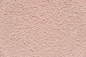 Beige chipped textured paint with sand on the wall. close up view
