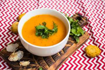 Orange hot pumpkin lentil soup in bowl. Spicy creamy soup with pumpkin puree.