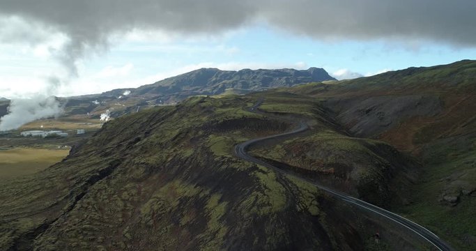 Car drving up winding mountian road Icelandic power plant aerial.mov