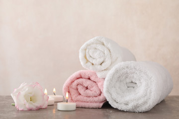 Fototapeta na wymiar Towels, candles and flower on grey background, space for text