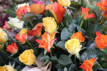 Blüten der Trauer in Orange und Gelb mit Rosen und Calla