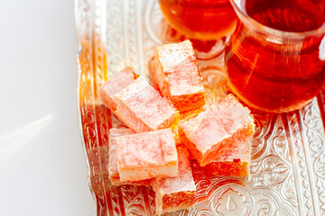 Turkish traditional  delight and tea in traditional glass on a silver vintage tray, close up