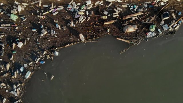 Aerial drone view waterfront scrap-heap plastic bottles rubbish pollution marine debris outdoors, environmental ecological natural disaster caused by human activity concept
