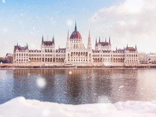 Rolgordijnen Hungarian parliament building at winter with snow. Snow lies on the river bank, Budapest © Evgeniya Biriukova