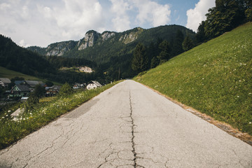 way through Mountain Village on a Sunny Summer day. old route in the foreground, mountains in the...