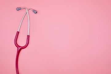 Fototapeta premium A pink stethoscope on the pink background
