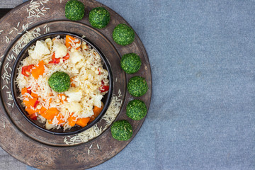 Colorful long basmati rice with vegetables in bowl with spinach green ball. Vegan or vegetarian healthy food.