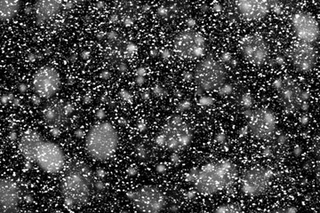 Texture of white snow blurry bokeh isolated black background. falling snow overlay. star sky. Black spots on white background, white drops and spots