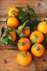 Fototapeta na wymiar Juicy fresh tangerines with leaves on the table 
