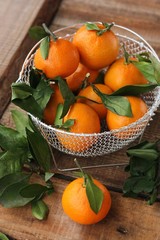 Juicy fresh tangerines with leaves on the table 