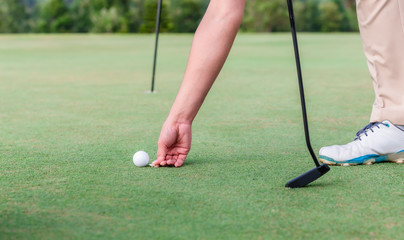 Male golf player using pin marking position of ball golf