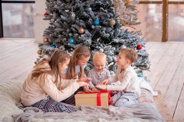 Happy kids having fun near christmas tree