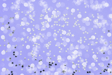 Holiday background. Star glitter on violet background. Top view